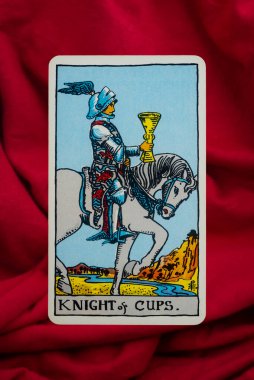 Yala Eyaleti, Tayland, 1 Haziran 2022 Kupa Şövalyesi. Kırmızı kumaş arka planda Tarot Kartı..