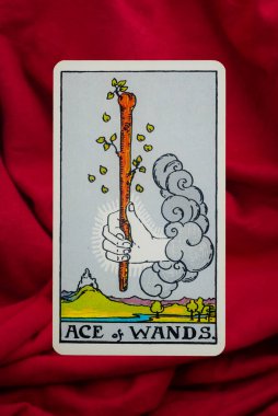 Yala Province, Thailand, June 1, 2022- Ace of Wands Tarot Card of Rider Waite deck on red fabric background. clipart