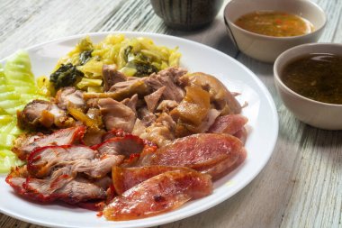 Domuz budu yahnisi, Kırmızı Domuz eti, Çıtır Domuz eti ve Çin sosisi. Beyaz tabakta salatalık ve salatalık turşusu ile servis ediliyor..