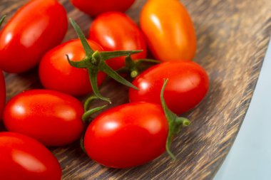 Fresh cherry tomatoes in a wooden dish. Contains vitamins A and C.