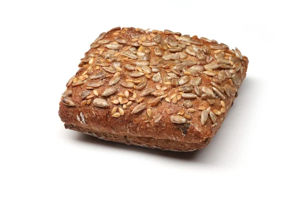 Çavdar ekmeği, beyaz arka plan üzerinde izole ayçiçeği çekirdeği ile tepesinde topuz — Stok fotoğraf
