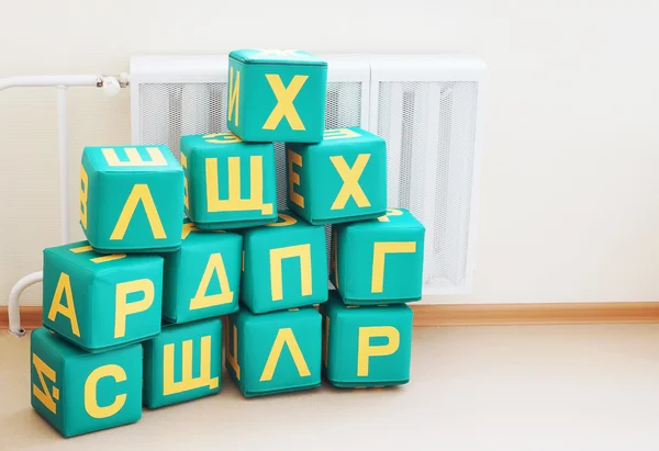 Large cubes with letters of Russian alphabet in a kindergarten