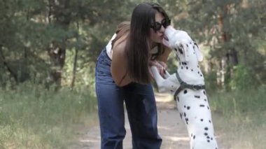 Bir Dalmaçyalı Köpek ve Kız. En iyi arkadaş. Köpekle oynamak, evcil hayvanla neşeli yürüyüş. Köpekle yürü..