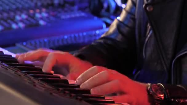 Manos masculinas tocando el teclado electrónico del piano. Colorida iluminación de escenario Dedos roscando almohadillas de tambor controlador midi. Músico produciendo canciones en el estudio de grabación en casa. Fabricante de sonido crear melodía de música — Vídeo de stock