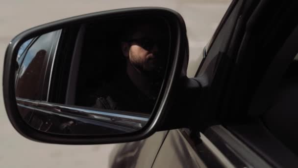 Молодой человек внутри машины. Красивый мужчина-водитель, сидящий в своем новом автомобиле. Вид в боковое зеркало парня Завтрак или обед в машине. — стоковое видео