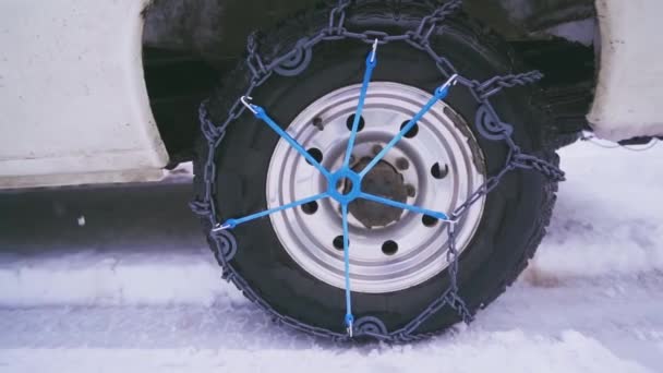 Snow chains mounted on a car. Driving on ice, Chains on wheels. — стоковое видео