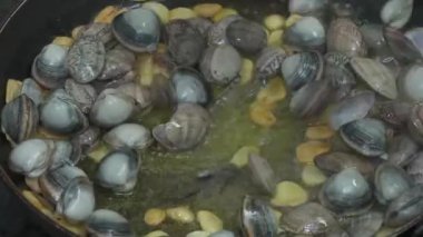 Restoranın mutfağında deniz mahsulleri pişirmek. Şef istiridye, kabuklu deniz hayvanı ya da tavada karıştırır. İştah açıcı balık yemeği. Kıyı yemekleri, deniz yemekleri..