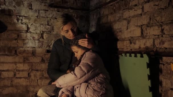 Guerra na Ucrânia. Abrigo. Bunker, mãe ucraniana e criança na cave. Com medo de sofrer e rezar pela paz durante o conflito de guerra. Refúgio. — Vídeo de Stock