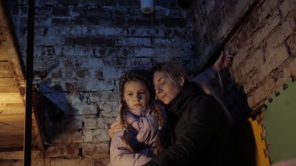 Убежище. Война на Украине. Убежище. Бункер, украинская мать и ребенок в подвале. Со страхом и молитвой о мире во время военного конфликта. — стоковое видео