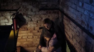 Ukrayna 'da savaş. Sivillerin vurulması. Ukraynalı aile bir sığınakta oturuyor. Bombardıman. Askeri harekat. Savaşı durdurun. Ukrayna 'da kriz, saldırganlık, savaşa karşı çocuk.
