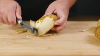 Çiğ patates. Patates yumrusu. Evde yemek pişirmek. Bitkinin kökü. Yürekli yemek. Nişasta ve karbonhidrat yiyecekler. Patatesleri soy..