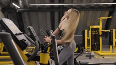 Formda kadınlar. Koşu bandında antrenörlük yapıyorum. Spor salonunda spor eğitimi ekipmanları. Simülatörlerde kardiyo rutini.