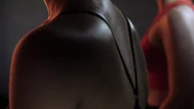 Formda kadınlar. Durağan bir bisiklette antrenman. Simülatörlerde kardiyo rutini. Spor salonundaki spor malzemeleri..