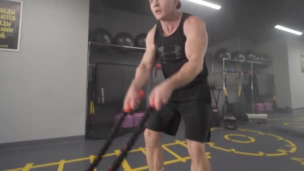Męski trening na siłowni. Trening gimnastyczny. Używając lin bojowych. Posiadanie sesji crossfit z linami bojowymi. — Wideo stockowe