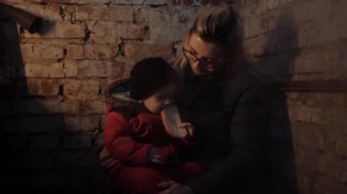 Ukrayna 'da savaş. Sığınak. Sivillerin vurulması. Ukraynalı anne ve çocuk bodrumda. Bombardıman. Askeri harekat. Ukrayna 'da kriz, saldırganlık. Savaş yok. Savaşı durdurun. Mülteci. Ukrayna savaşı.