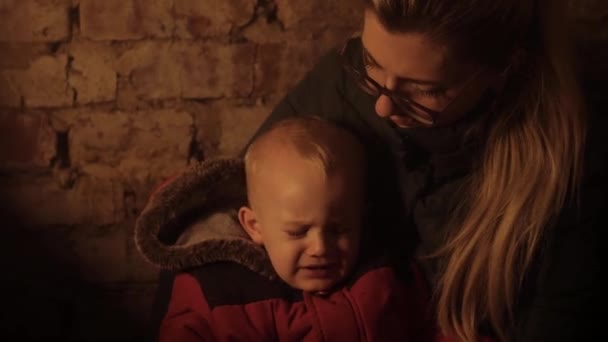 War in Ukraine. Ukrainian genocide. Bomb shelter. Ukrainian mother and child in the basement. Bombardment. Ukraine war, aggression. Refuge. — Stock Video