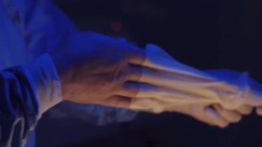 Doctors hands takes off medical gloves after surgery. The surgeon has finished his work.