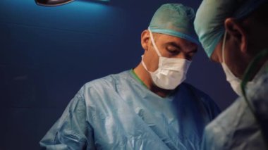 Doctors hands takes off medical gloves after surgery. The surgeon has finished his work.