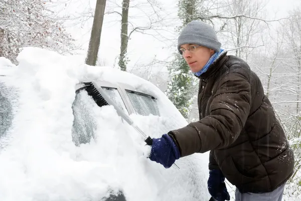 Man tar bort snö från sin bil — Stockfoto