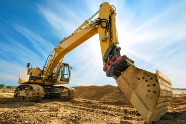 Big excavator in front of the blue sky clipart