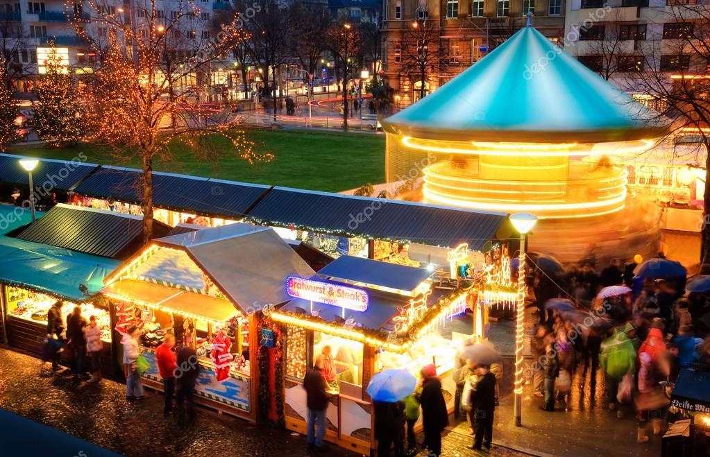Illuminated Christmas fair with loads of movement, people in motion, no logos or faces
