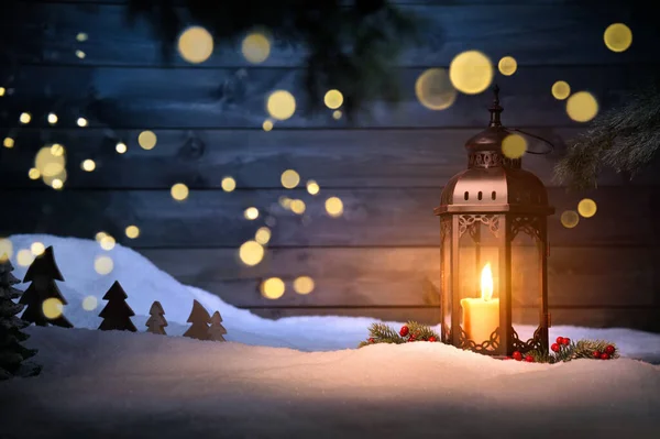 装飾品やぼやけた光が暗い木製の壁の前にぶら下がっているクリスマスシーン クールな青の背景とは対照的に暖かい金のキャンドルライト — ストック写真