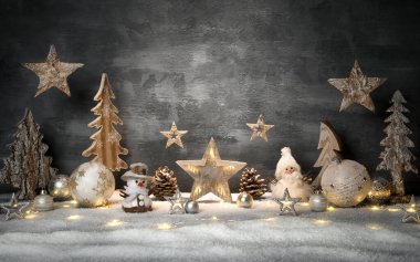 Gri renkli arka plan ve fotokopi alanı, asılı yıldızlar ve parlak süslemeler ve karda ışıklar ile Noel süslemeleri.