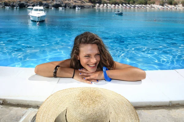 Ragazza bionda con berretto di paglia in piscina — Foto Stock