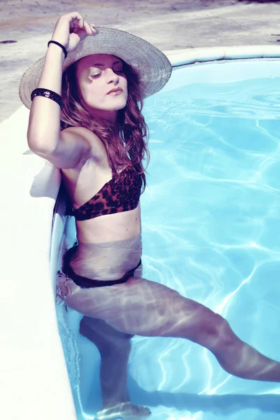 Blonde fille avec chapeau de paille dans la piscine — Photo