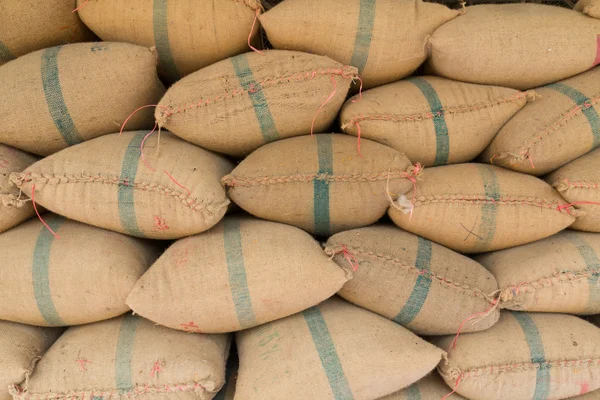 Velhos sacos de cânhamo contendo arroz colocados profundamente empilhados Fotografia De Stock