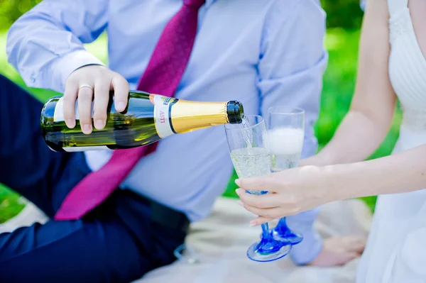 Vőlegény önti pezsgőspoharak kézzel menyasszony — Stock Fotó