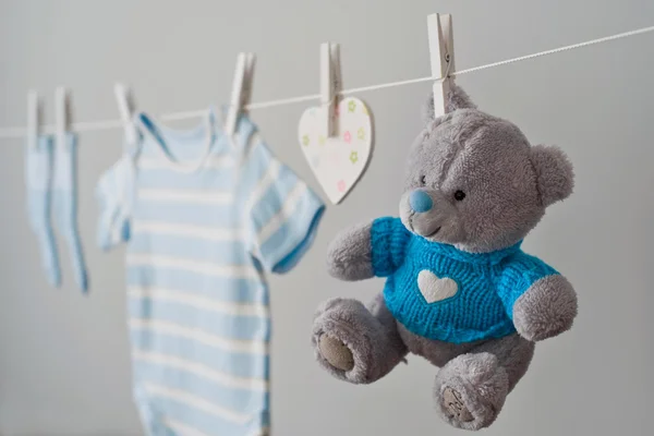 Vêtements de bébé bleu sur la corde à linge — Photo