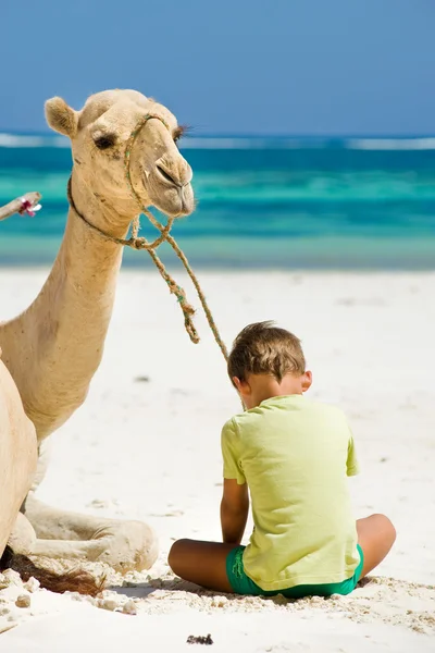 Kind und Kamel am Strand — Stockfoto