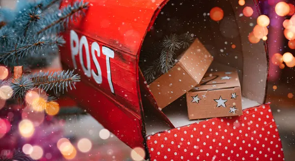 Rode kerstbrievenbus met geschenkdozen en een wenskaart van de kerstman. — Stockfoto