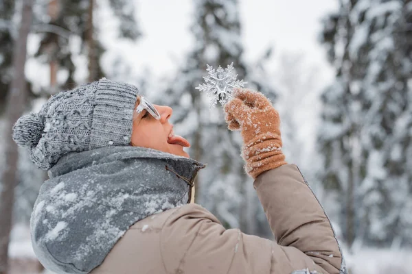 Tiempo de invierno Mujer vestida gris de moda con gafas de sol lanza divertirse, la captura de copos de nieve con la lengua. — Foto de Stock