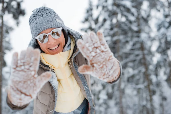 Mujer feliz caminando al aire libre en un día de invierno nevado. Mujer feliz alegre vestido gris de moda con gafas de sol — Foto de Stock