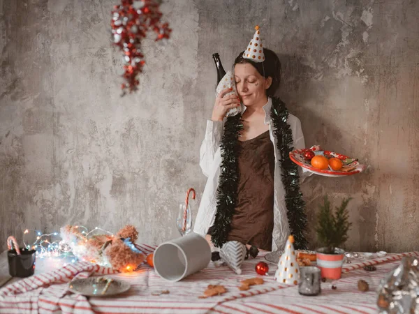 Woman has a hangover after a holiday in the morning with a bottle of alcoholic champagne — Fotografia de Stock