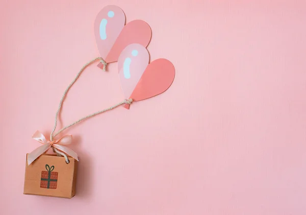 Flatley con el concepto de un regalo en globos en forma de un corazón vuela entrega de compras para unas vacaciones con felicitaciones. — Foto de Stock