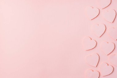 Pembe kağıt üzerinde uçan kalp şeklinde kağıt elementler. Aşk ve Sevgililer Günü konsepti, 8 Mart, Kadınlar Günü, Anneler Günü. Doğum günü tebrik kartı tasarımcısı.