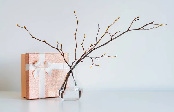 Festive banner with pink pastel colors with a gift box and a branch of a spring vase. — Stock Photo, Image