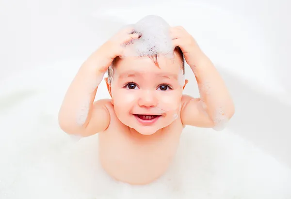 Szczęśliwe dziecko pralki w łazience w pianki — Zdjęcie stockowe
