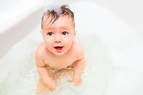 Pequeno bebê espirrando no banho — Fotografia de Stock