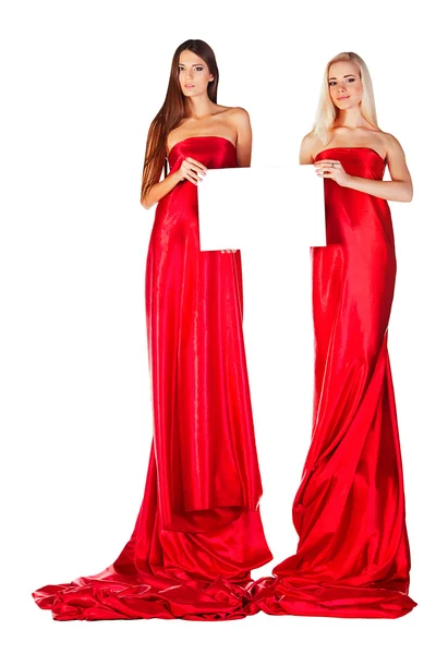 Two women in red dress with magazine in hands — Stock Photo, Image