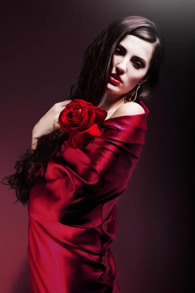 Beautiful woman in red fabric with red rose — Stock Photo, Image