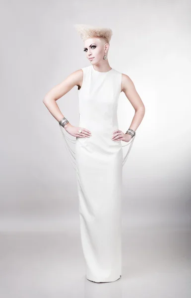 Blond mooie vrouw in lange witte jurk met creatieve hairstyl — Stockfoto