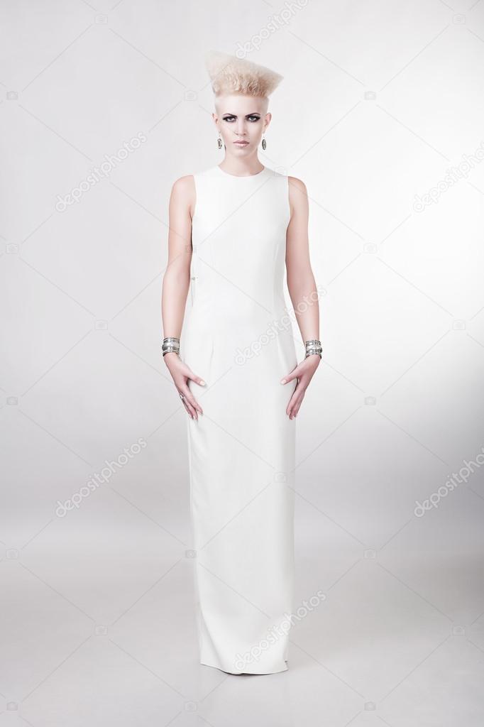 attractive blond woman in long white dress with creative hairsty