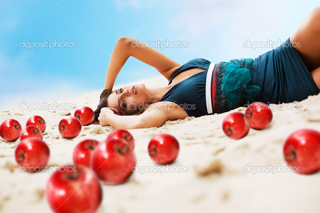 Woman with red apples on the sand