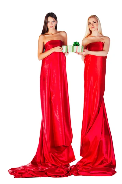 Deux femmes en robe rouge avec présent dans les mains — Photo