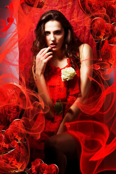 Mooie warme vrouw verliefd in rode jurk rond stof — Stockfoto