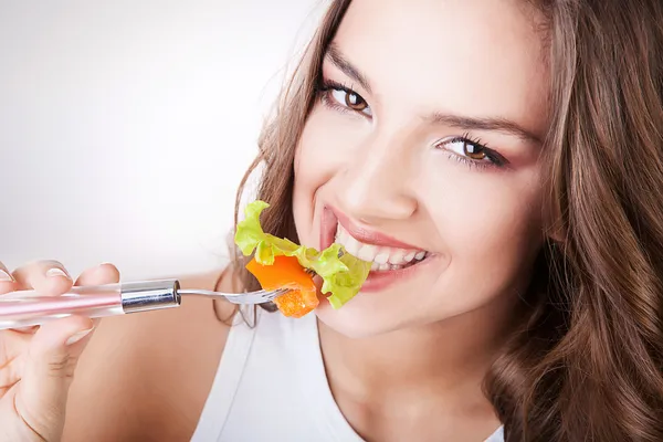 Sexy lächelnde Frau isst Salat — Stockfoto